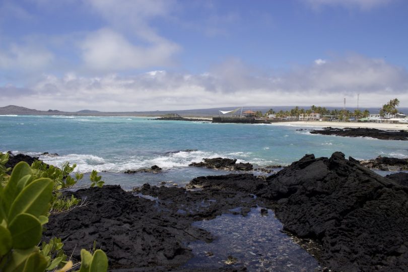 Black volcanic sand beach and turquoise ocean during a September Galapagos cruise with Cruises to Galapagos Islands