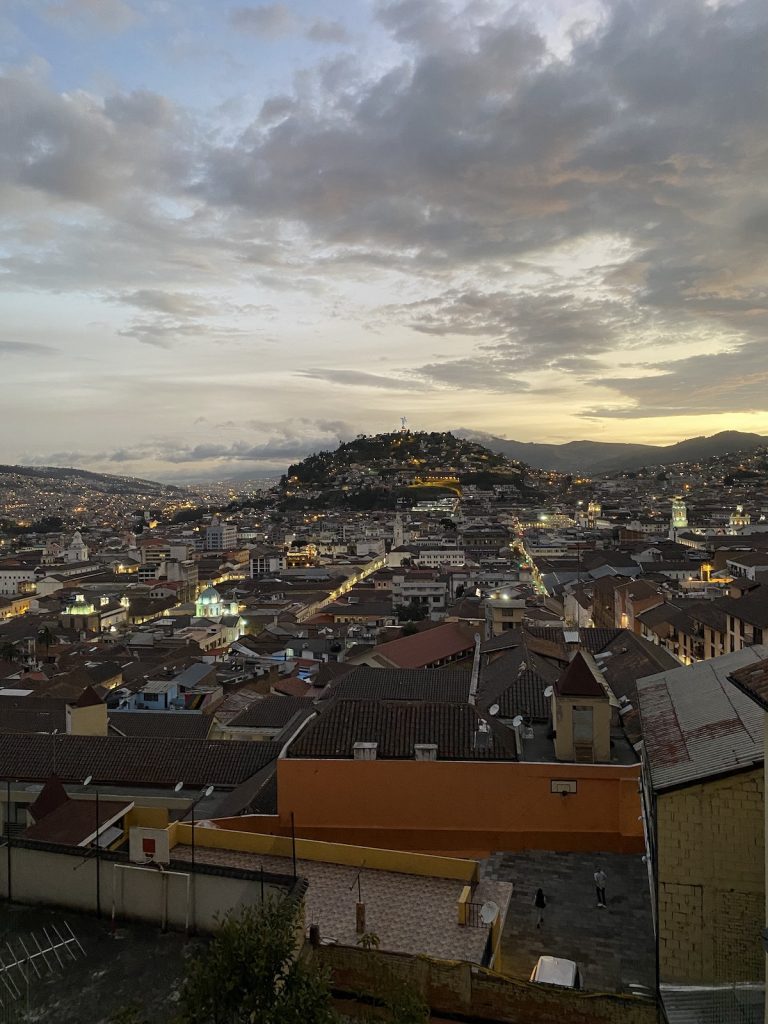 Evening view across Quito’s highland city center and surrounding mountains before a Galápagos cruise with our agency