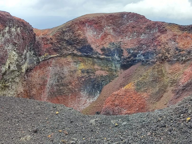Colorful volcanic crater on Fernandina Island with red, black and yellow mineral-rich rock during a Galápagos cruise with our agency